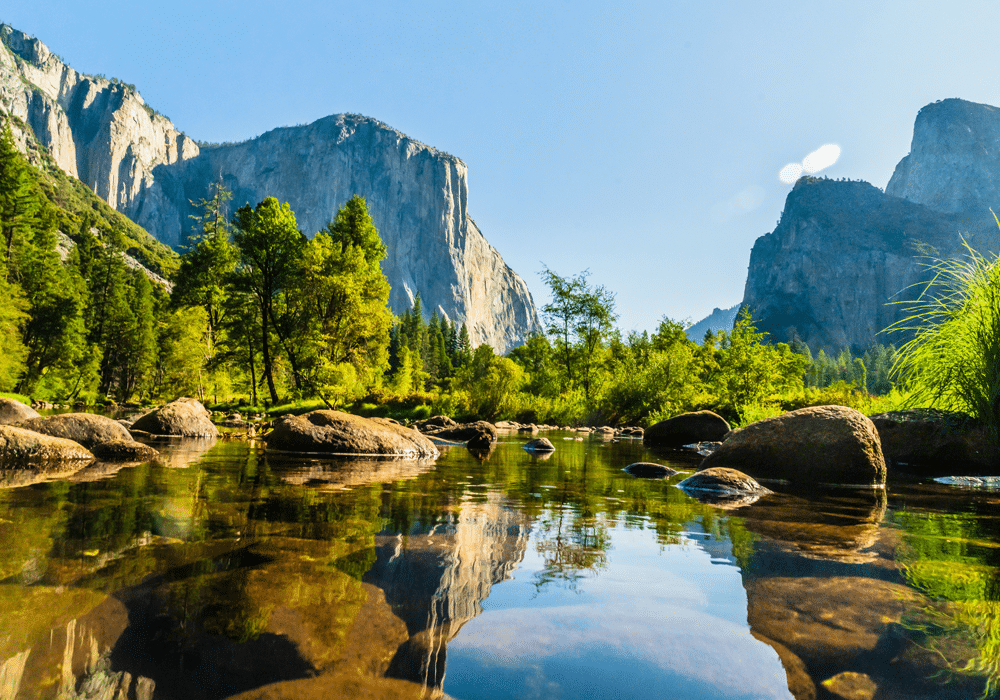 calm lake view with river rocks and mountains in the background